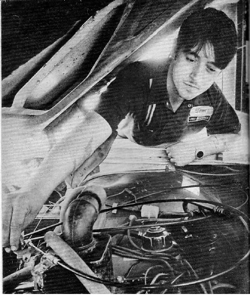 Tom Ogle inventor of a super carburetor, under the hood of a v8